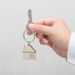 Woman hand holding house model and key