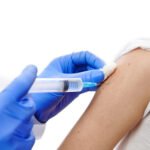 Vaccination. Doctor making vaccine injection on child hand