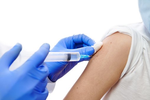 Vaccination. Doctor making vaccine injection on child hand